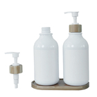 Άσπρο μπουκάλι λοσιόν λουτρών με την αντλία μπαμπού για το πλύσιμο σαμπουάν και σώματος