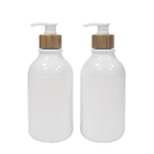 Άσπρο μπουκάλι λοσιόν λουτρών με την αντλία μπαμπού για το πλύσιμο σαμπουάν και σώματος